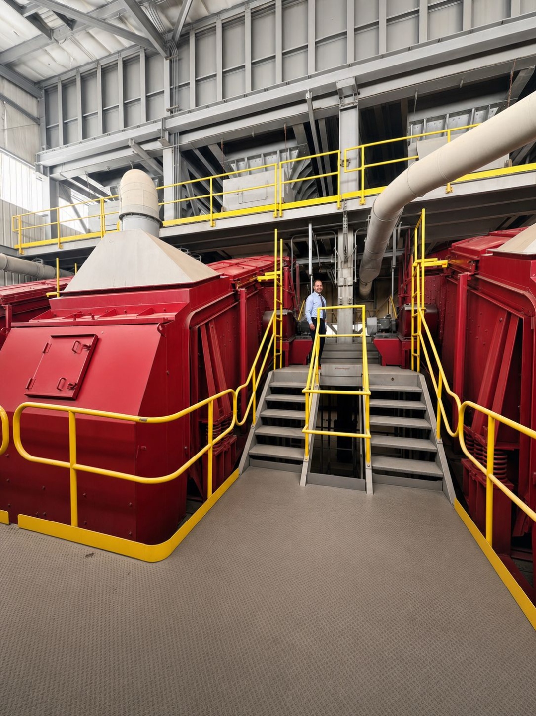 Red-painted heat-treat furnaces with operator on inspection landing